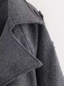Close-up of lapel and shoulder tailoring on a grey wool blend long coat for women