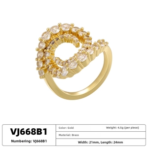 Macro shot of G-shaped gold ring with pavé zirconia crystals on white background