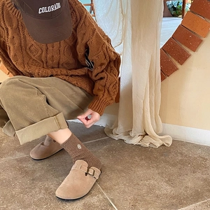 Detail of warm brown knit mid-tube socks with embroidered pattern and beige mule shoes