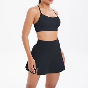Détail de la brassière de sport noire et de la jupe-short à taille haute fendue