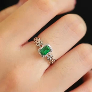 Anello in argento con smeraldo verde rettangolare e design a catena cava al dito