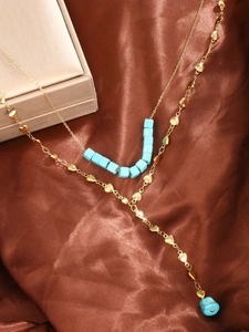 Detailed close-up of double-layer turquoise necklace on brown silk fabric