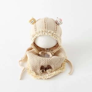 Detalle de conjunto de gorro y bufanda de punto para bebé con encaje y lazo de cuadros