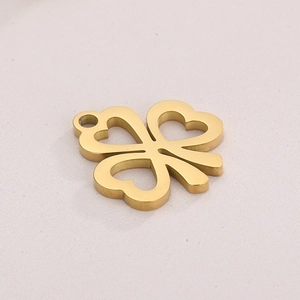 Macro detail of gold plated hollow clover pendant with heart shaped petals and top bail