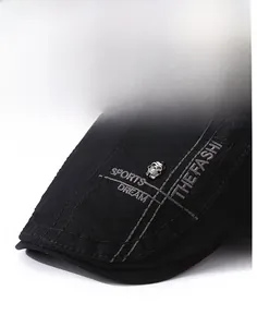 Detail of black beret featuring metal skull rivet and embroidered white sports lettering