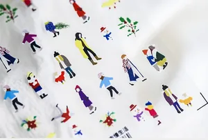 Detailed view of ultra-thin winter cartoon nail art stickers on textured white fabric