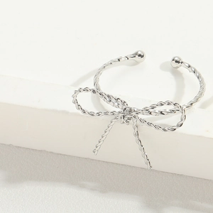 Detailed view of a silver twisted texture open bangle with a central bow knot design