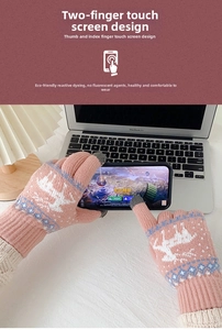 Detailopname van roze gebreide winterhandschoenen met touchscreen-ontwerp en rendierpatronen