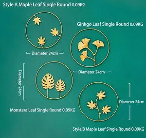 Detail of four golden metal leaf wall decors featuring maple, ginkgo and monstera designs