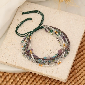 Close-up of Bohemian handmade multi-layer beaded bracelet with green woven rope and crystals