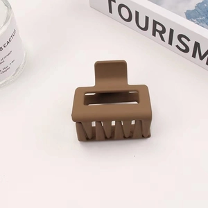 Detail shot of a square matte brown hair claw clip with smooth rubberized finish texture