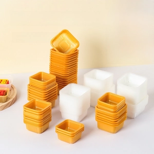 Close-up of food-grade square mooncake blister trays in gold and white stacked together