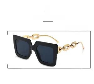 Detail of stylish oversized square sunglasses with decorative gold chain link temples
