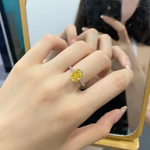 Close-up of S925 sterling silver ring with yellow zircon on hand with mirror reflection