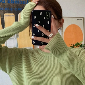 Mirror selfie showing the texture of a grass green ribbed knit long sleeve sweater