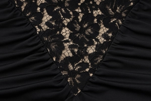 Close-up of V-neck floral lace patchwork and ruched detailing on a black bodycon dress