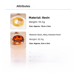Close-up of retro wide resin bangles in amber yellow and tortoiseshell with pearl accents