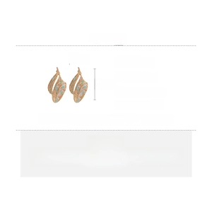 Detailed view of hollow leaf earrings in gold alloy with blue enamel and silver needles