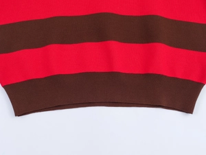 Gros plan sur un polo en tricot rayé rouge et brun avec ourlet côtelé et texture fine