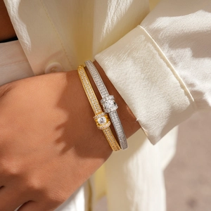 Detailed close-up of gold and silver plated oval bangles with pavé diamond settings