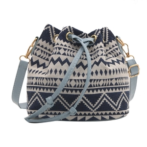 Ethnic style woven bucket bag with blue geometric patterns and leather drawstring strap