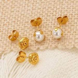 Détails de boucles d'oreilles rose dorée et perles blanches avec serti à griffes