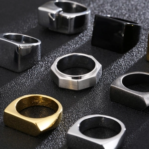 Collezione di anelli geometrici da uomo in oro, argento e nero su espositore strutturato