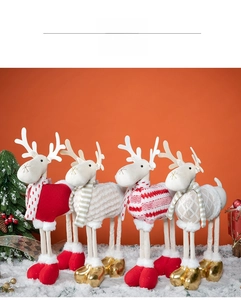 Set of four plush Christmas reindeer dolls in colorful sweaters on artificial snow
