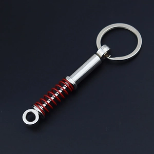 Detailed close-up of a metal shock absorber keychain with a red spring and silver ring