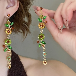 Detailansicht der glitzernden Blumen-Ohrringe mit bunten Kristallen und Gold-Finish