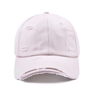 Detail of light pink distressed cotton baseball cap with ripped effects on the brim and crown