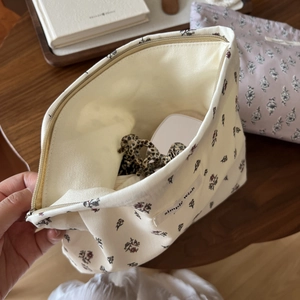 Detail view of cotton floral cosmetic bag showing interior storage space and zipper