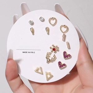 Detailed close-up of 7-day earring set featuring gold-toned alloy with rhinestones and pearls
