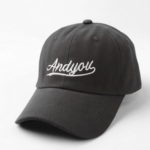 Detail showing white Andyou cursive embroidery on dark grey cotton baseball cap