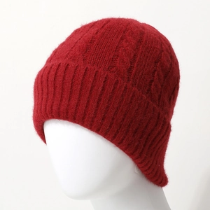 Red cable knit beanie for winter featuring a thick ribbed cuff on a white model head