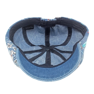 Detail view of cotton denim beret showing floral print and soft inner cotton lining