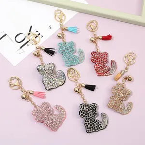 Close-up of sparkling crystal cat keychains with leather tassels in six vibrant colors