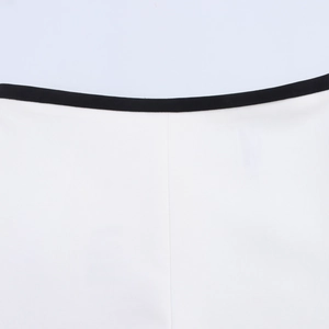 Close-up of white fabric with black contrast trim on the waistband of the two-piece set