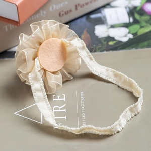 Elegant beige floral headband for baby girls featuring soft ruffled fabric flowers