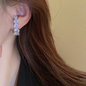 Macro side view of silver curved ear cuff with four round white cubic zirconia stones
