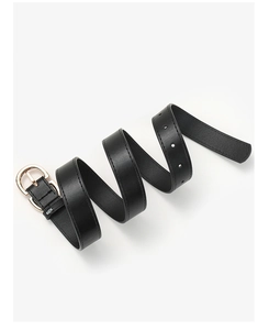 Detail of minimalist black leather belt featuring polished gold buckle and fine texture