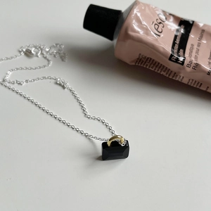 Detail of 925 sterling silver chain with black rectangular gemstone and gold connector