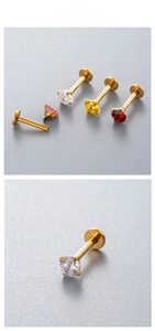Macro detail of titanium labret studs with colorful round-cut cubic zirconia in gold plating
