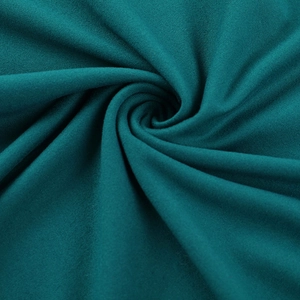 Gros plan du tissu en maille bleu sarcelle avec drapé en spirale et texture douce et fine