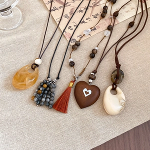 Detailed close-up of vintage ethnic necklaces featuring resin, wood and stone pendants