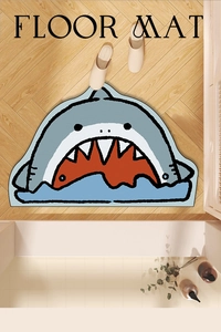 Detail view of cartoon shark non-slip bath mat on wood floor with cute animal shape