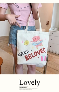 Detail of white canvas tote bag featuring cute cartoon pig and chick illustration