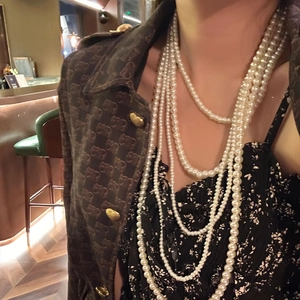 Elegant multi-layer white pearl necklace for women, layered bead strands worn by a model