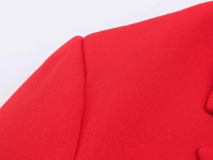 Close-up of bright red blazer fabric texture and precision shoulder stitching details