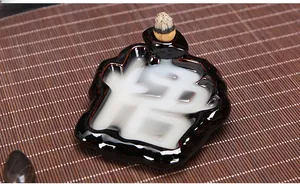 Close-up of ceramic backflow incense burner showing smoke forming a Zen character